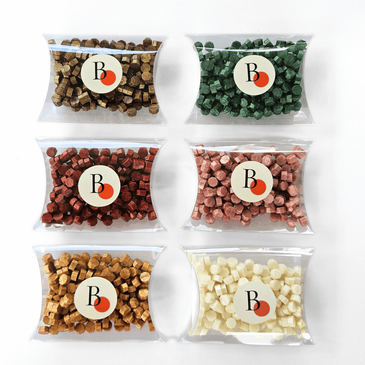 Six packages of sealing wax beads in green, bronze, red, pink, gold and white