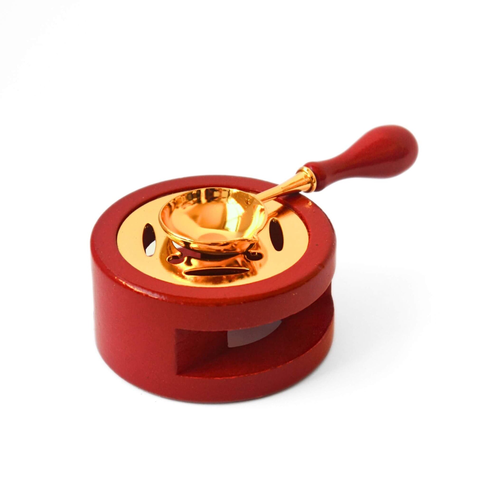 Bpunde terracotta and gold wax melting stove with spoon sitting on top