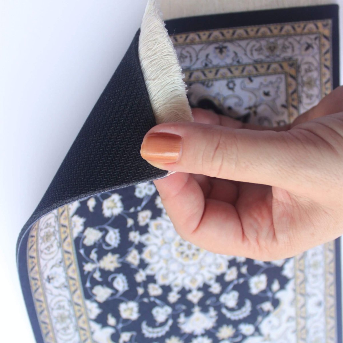 Hand showing underside of oriental carpet mouse pad