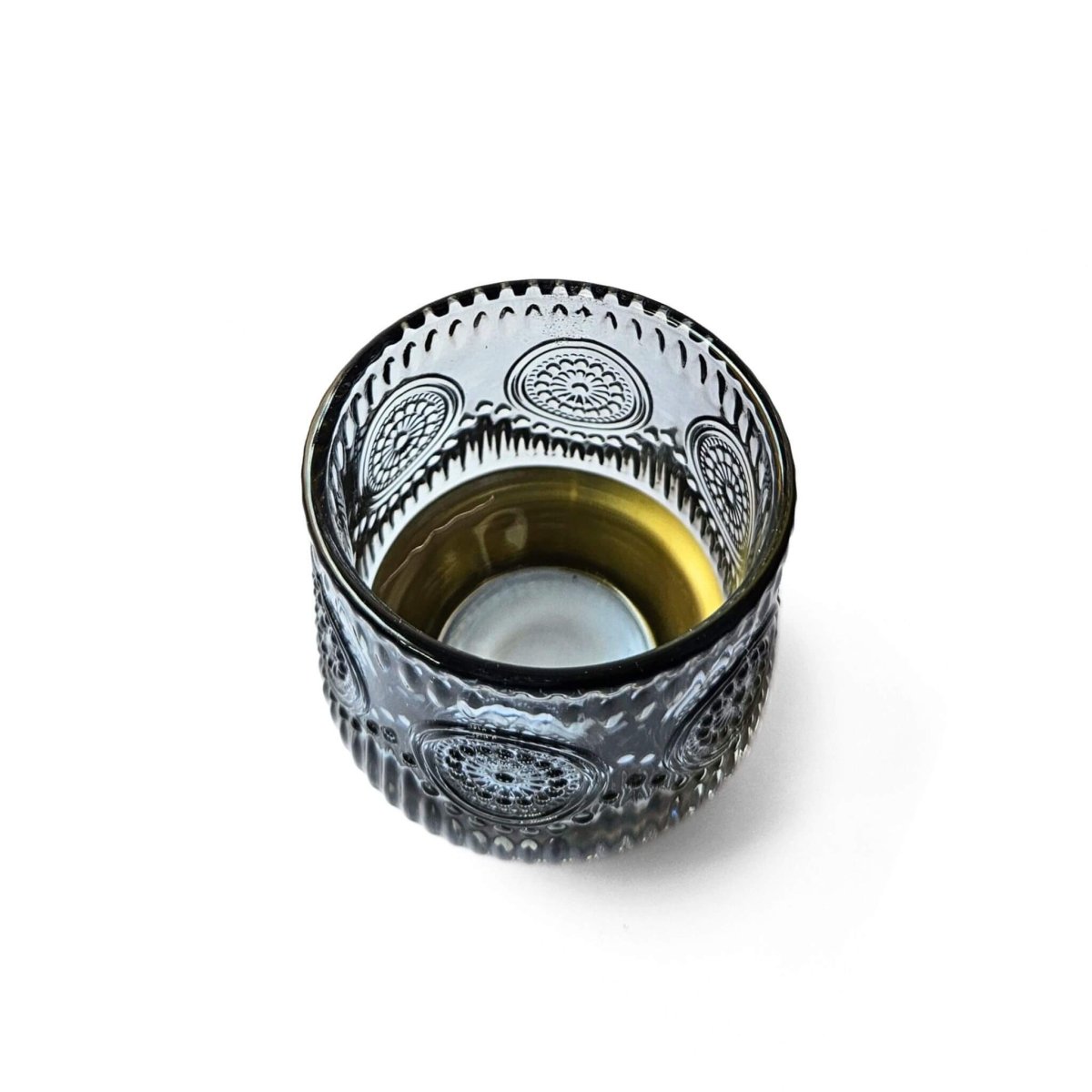 Decorative blue glass candle holder with gold base and intricate patterns on a white background