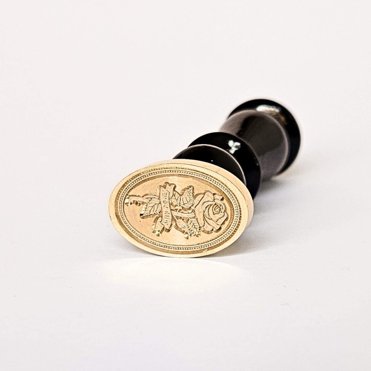 Oval shaped wax seal with rose design on white background