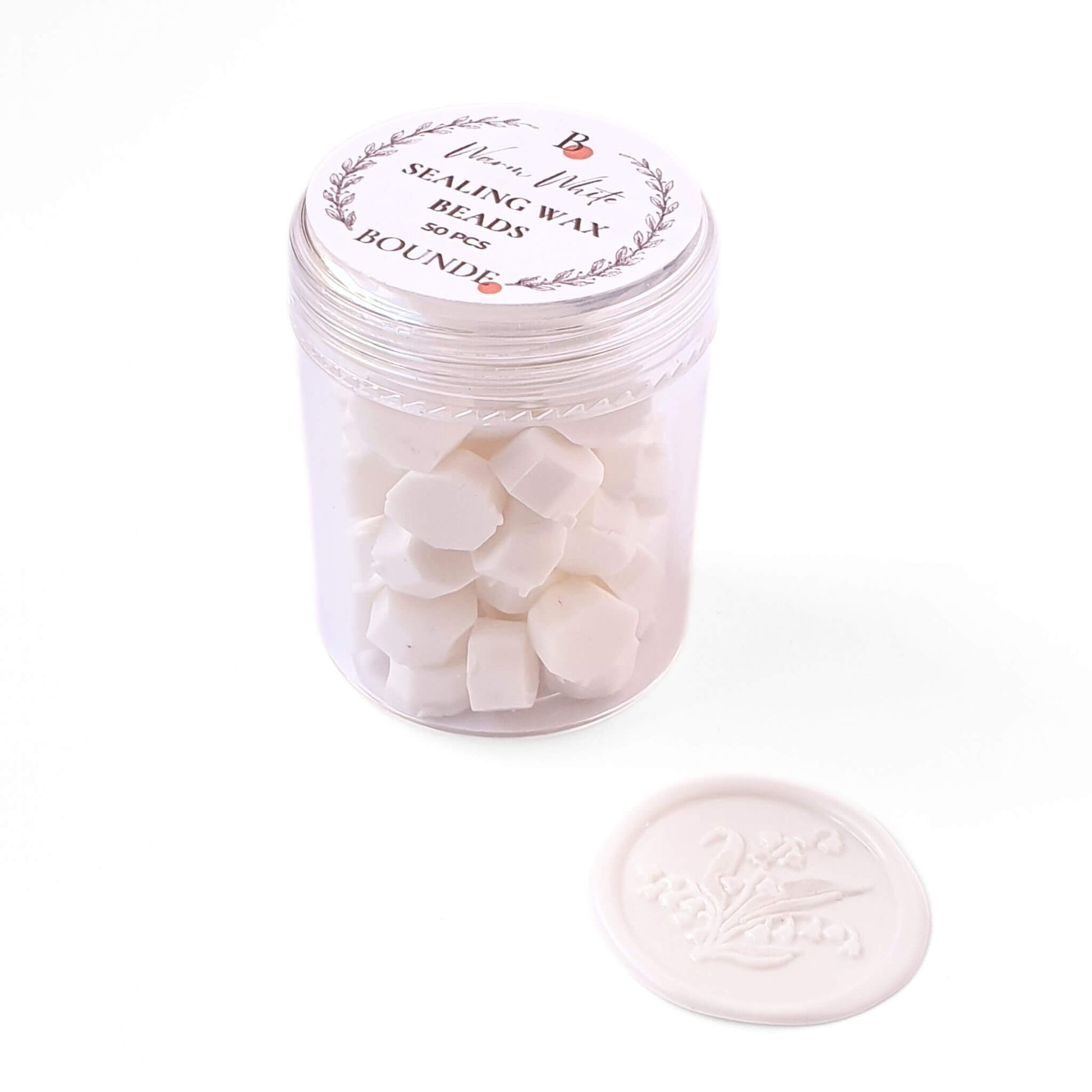 Jar of white sealing wax beads and a white wax seal stamp