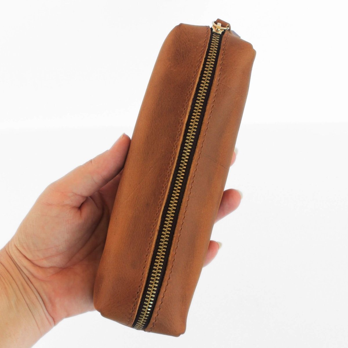 hand holding brown leather pencil case