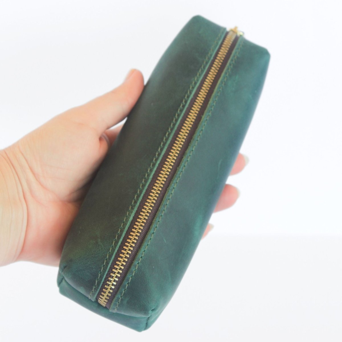 hand holding green leather pencil case