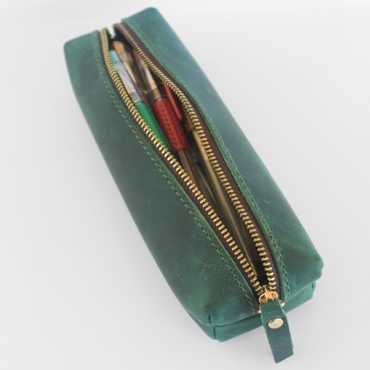 open leather pencil case with pens inside